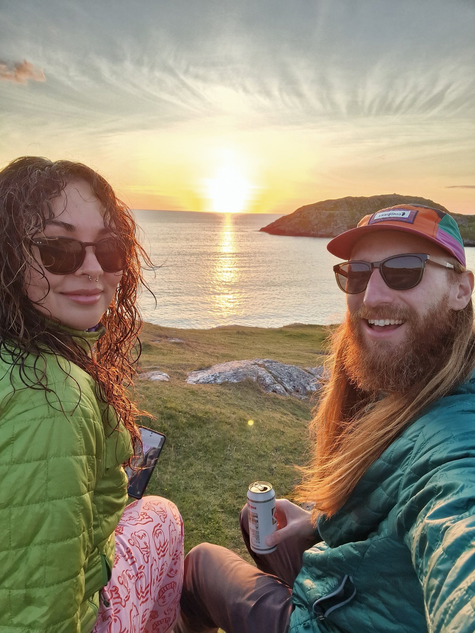 A photo of Ant and Bex at a Scottish Coast with the sun setting behind them.
